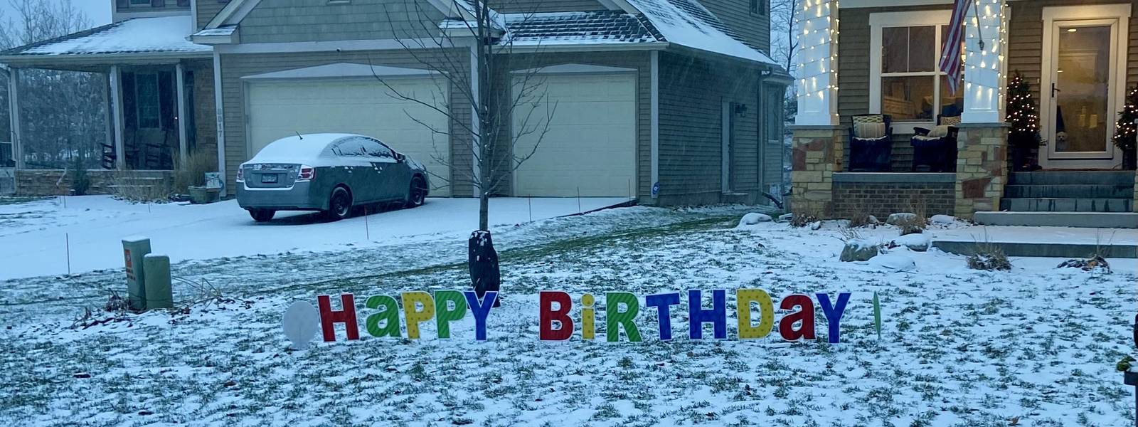 A Happy Birthday yard sign in fresh snow