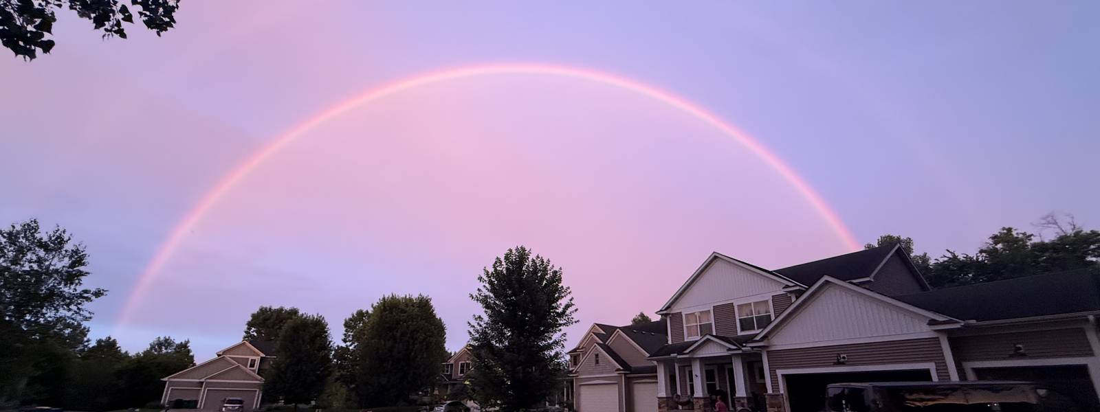 A rainbow over Hidden Valley homes at dusk